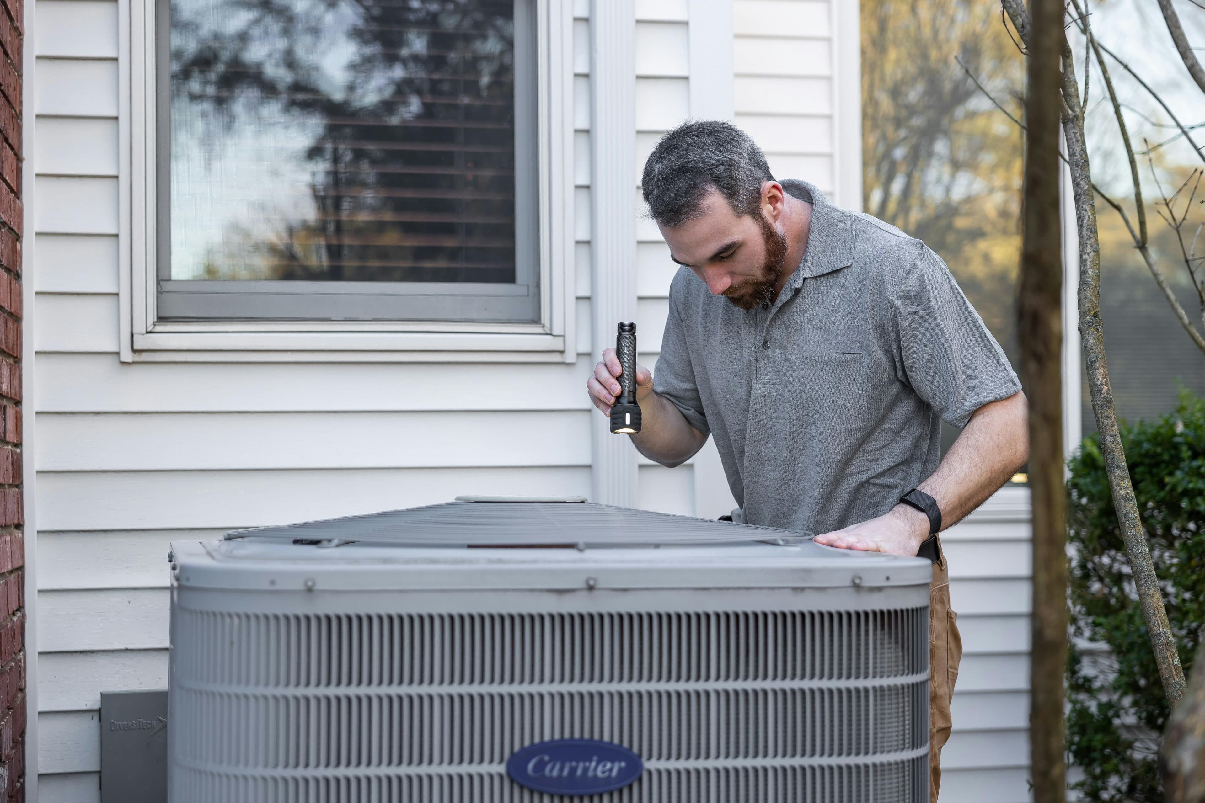 HVAC technician servicing equipment on a job site